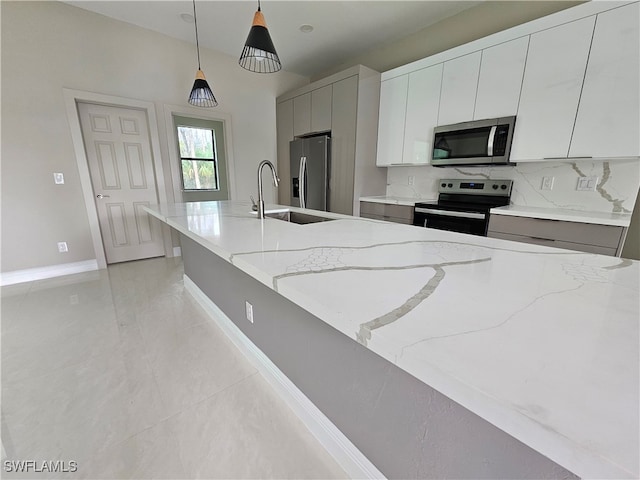 kitchen with stainless steel appliances, sink, light stone counters, pendant lighting, and decorative backsplash