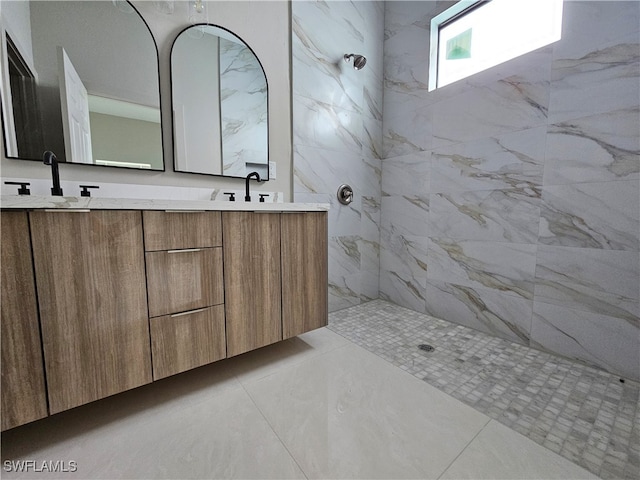 bathroom with tiled shower, tile patterned floors, and vanity