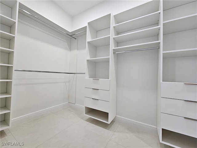 spacious closet with light tile patterned floors