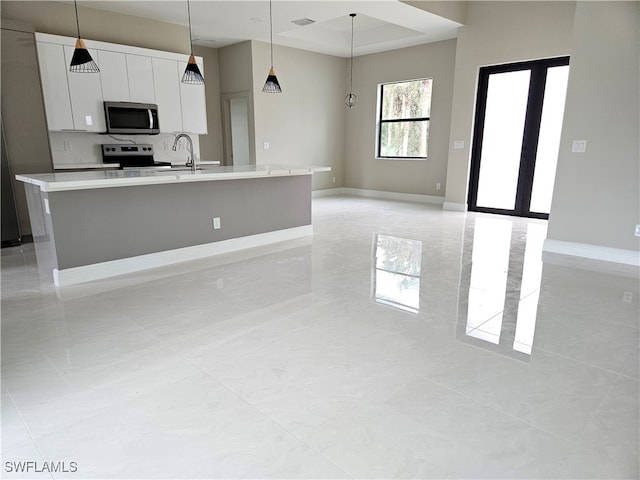 kitchen featuring stainless steel appliances, a kitchen island with sink, light tile patterned flooring, white cabinetry, and decorative light fixtures