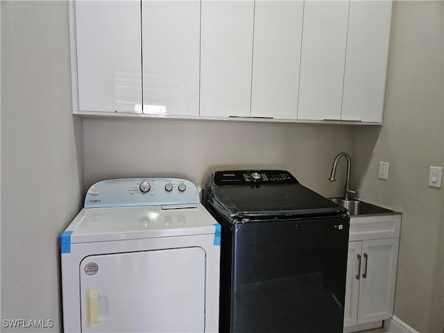 washroom with washing machine and clothes dryer, cabinets, and sink