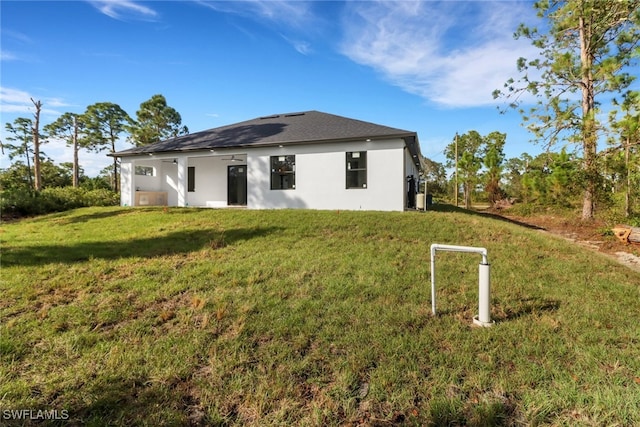 rear view of property with a lawn