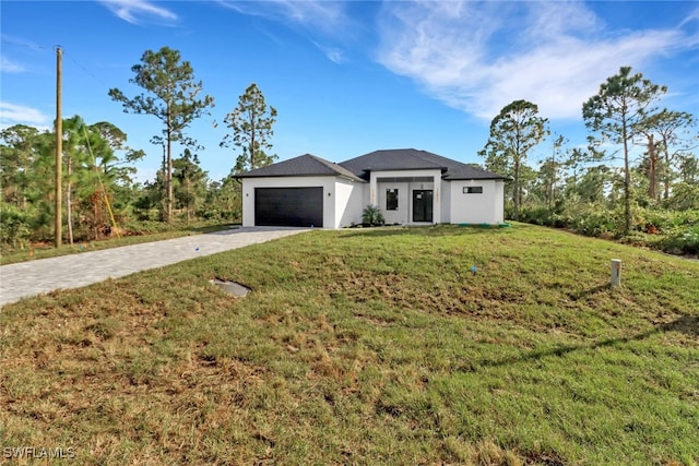 view of front of property featuring a garage and a front lawn