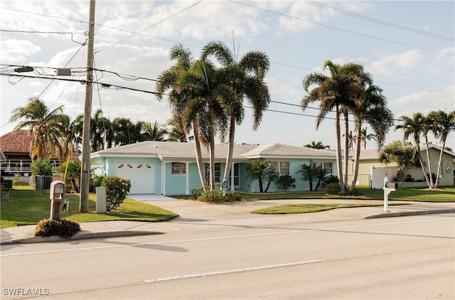 ranch-style house with a garage and a front lawn