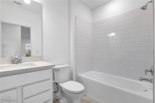 full bathroom featuring toilet, tiled shower / bath combo, and vanity