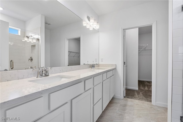 bathroom featuring tile patterned flooring, vanity, and a shower with shower door