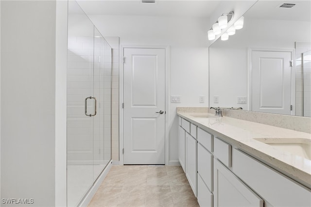 bathroom with vanity, tile patterned floors, and a shower with door