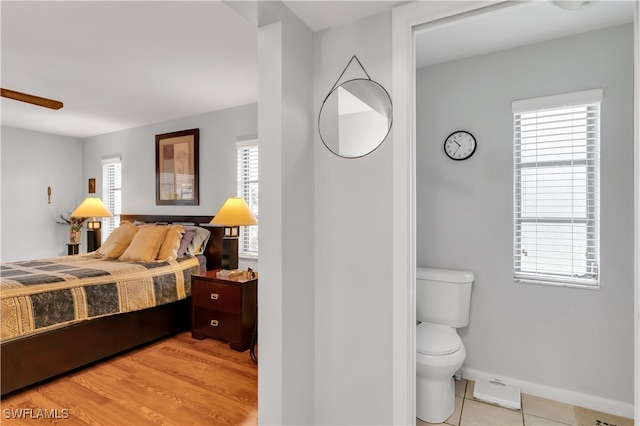 bedroom with multiple windows and light hardwood / wood-style flooring