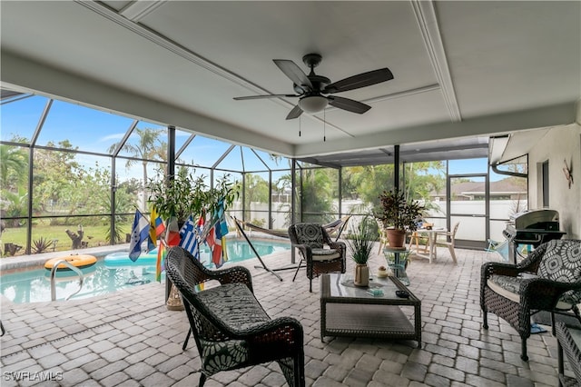 sunroom with ceiling fan and a swimming pool