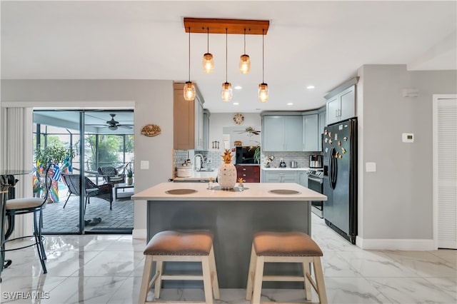 kitchen with ceiling fan, a kitchen breakfast bar, backsplash, decorative light fixtures, and black fridge with ice dispenser