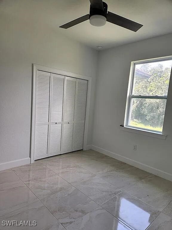 unfurnished bedroom featuring a closet and ceiling fan