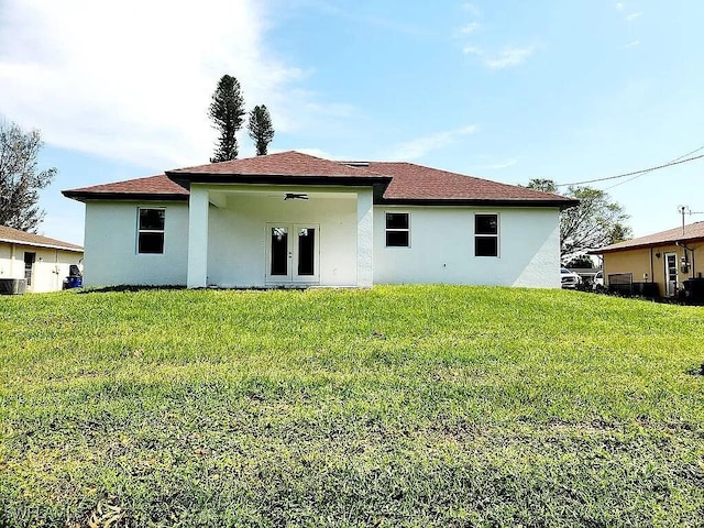 rear view of property with a yard, french doors, and ceiling fan