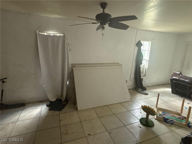 interior space with light tile patterned floors and ceiling fan