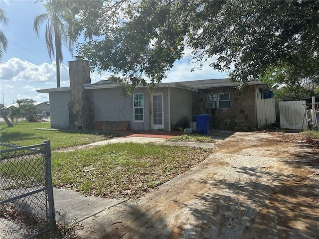 view of front facade with cooling unit and a front lawn