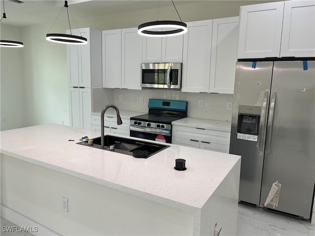 kitchen with hanging light fixtures, white cabinetry, sink, and appliances with stainless steel finishes