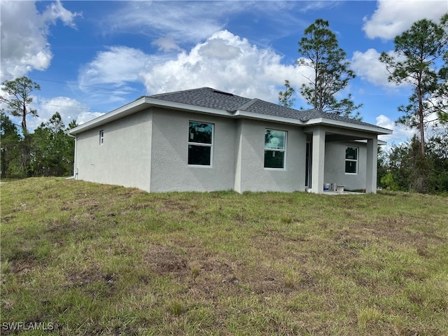 rear view of house featuring a lawn