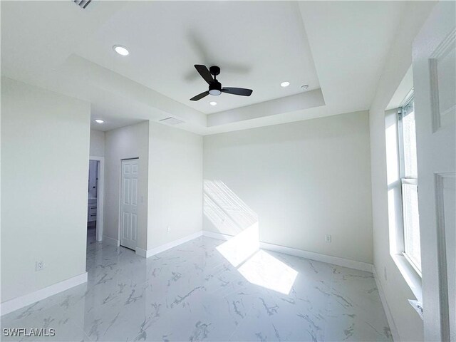 unfurnished room with a tray ceiling and ceiling fan