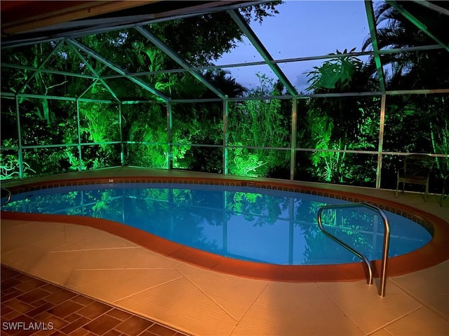 view of swimming pool featuring a lanai