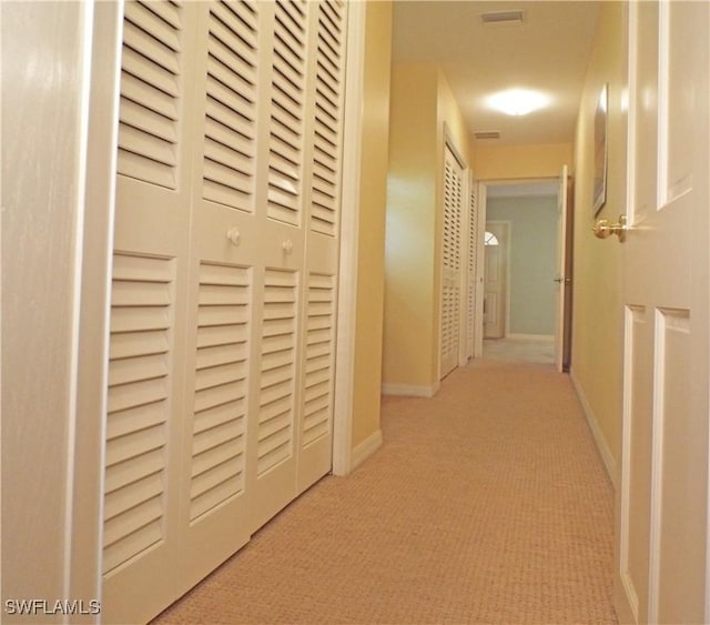 corridor featuring light colored carpet