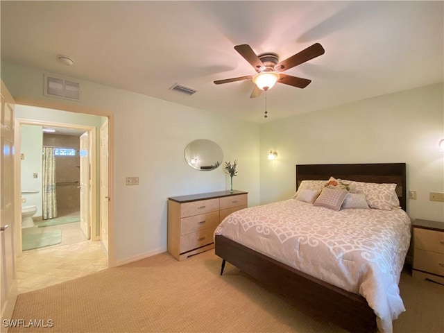 bedroom with ceiling fan, light carpet, and connected bathroom