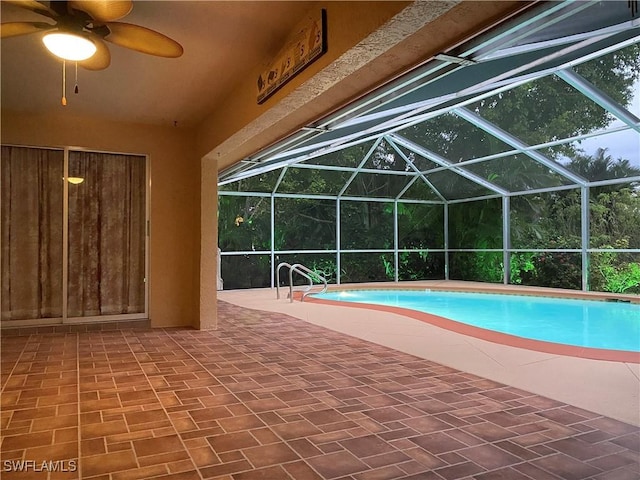 view of swimming pool featuring ceiling fan, a patio area, and a lanai