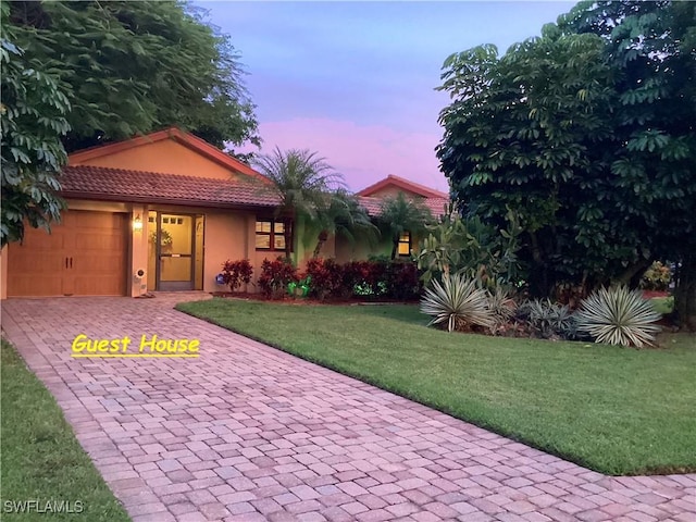 view of front of house featuring a garage and a yard