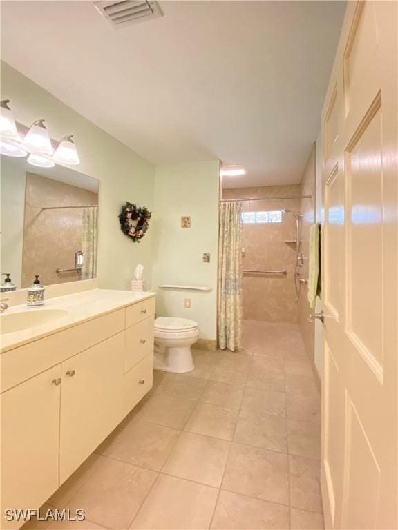 bathroom with tile patterned floors, vanity, a shower with shower curtain, and toilet