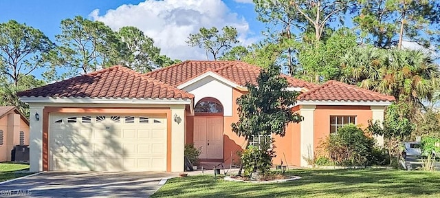 mediterranean / spanish home with concrete driveway, a tiled roof, an attached garage, stucco siding, and a front lawn