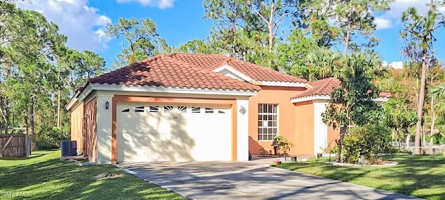 mediterranean / spanish-style home with a front lawn, a garage, and central AC