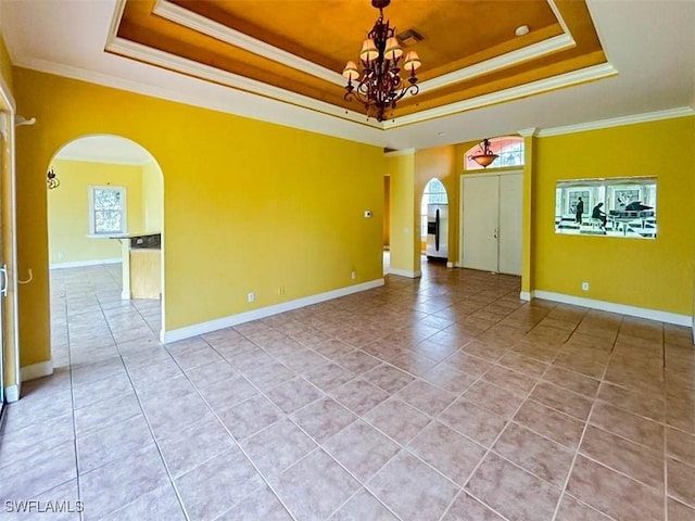 spare room featuring arched walkways, a tray ceiling, a chandelier, crown molding, and light tile patterned floors