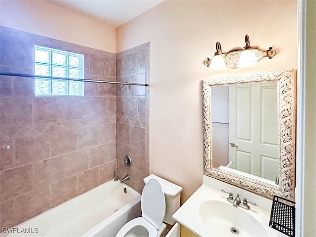 full bathroom featuring vanity, tiled shower / bath combo, and toilet