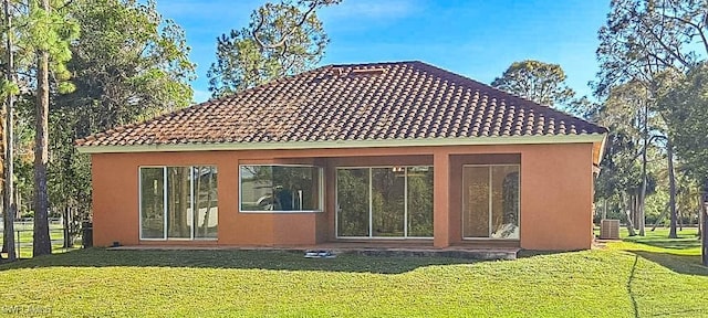 rear view of property with stucco siding, a tile roof, and central AC