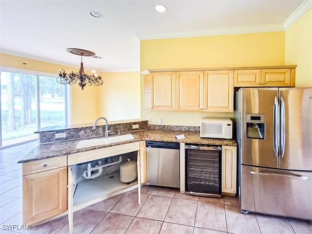 kitchen featuring appliances with stainless steel finishes, a sink, wine cooler, light brown cabinets, and ornamental molding