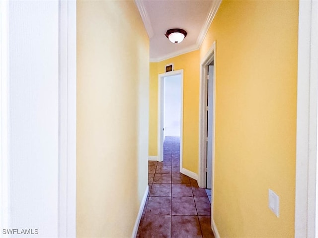 hallway with dark tile patterned flooring and ornamental molding