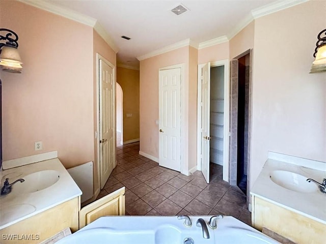 full bathroom featuring a closet, two vanities, tile patterned flooring, a bath, and ornamental molding
