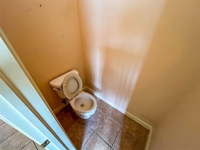 bathroom with tile patterned floors, toilet, and baseboards