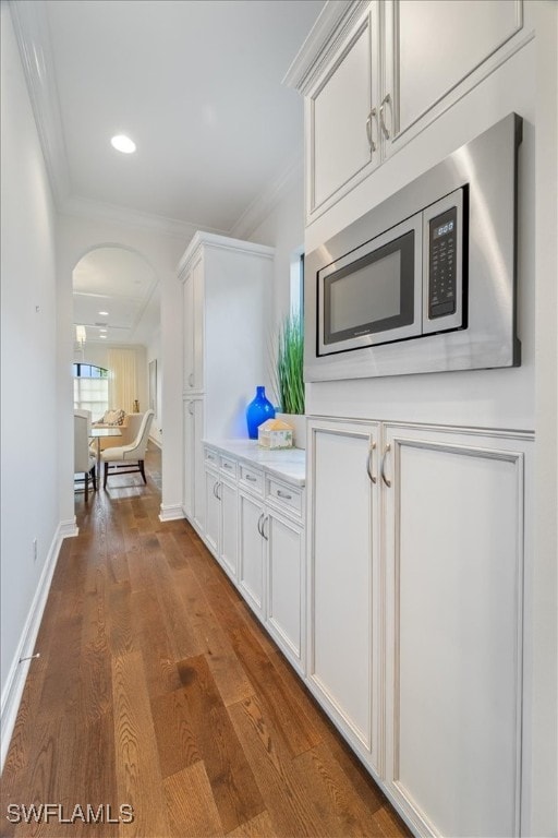 kitchen with dark hardwood / wood-style floors, white cabinetry, and stainless steel microwave