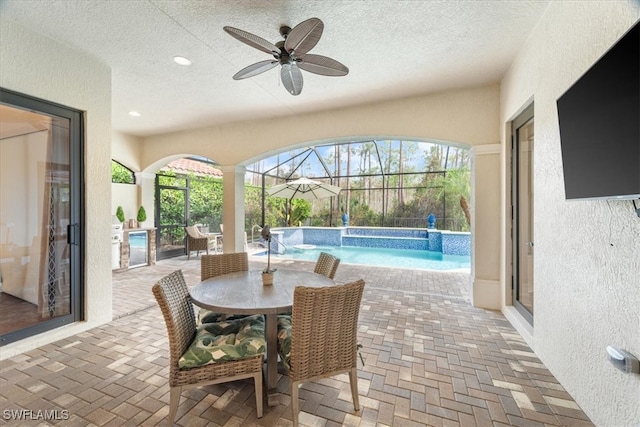 sunroom featuring ceiling fan and a pool