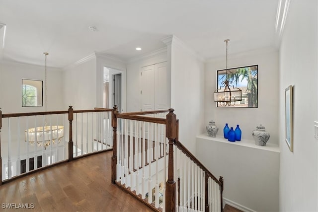 corridor featuring crown molding, dark wood-type flooring, and a notable chandelier