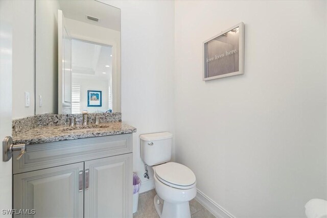 bathroom with tile patterned flooring, vanity, and toilet