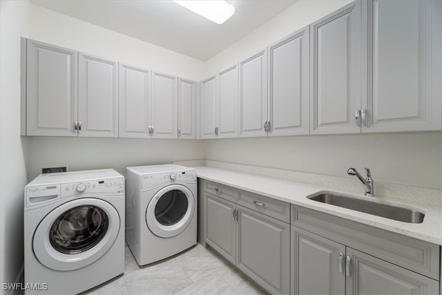 laundry area with separate washer and dryer, sink, and cabinets