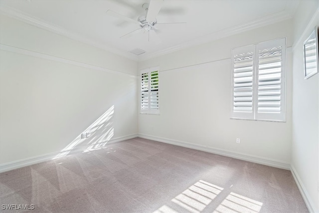 spare room with plenty of natural light, ceiling fan, light colored carpet, and crown molding