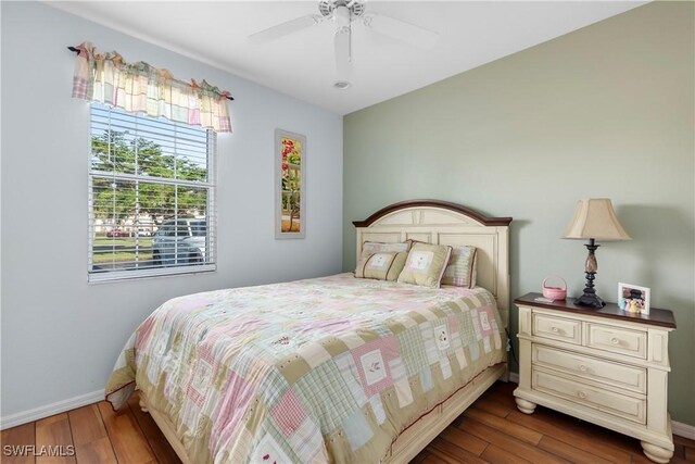 bedroom with ceiling fan, dark wood-type flooring, and baseboards