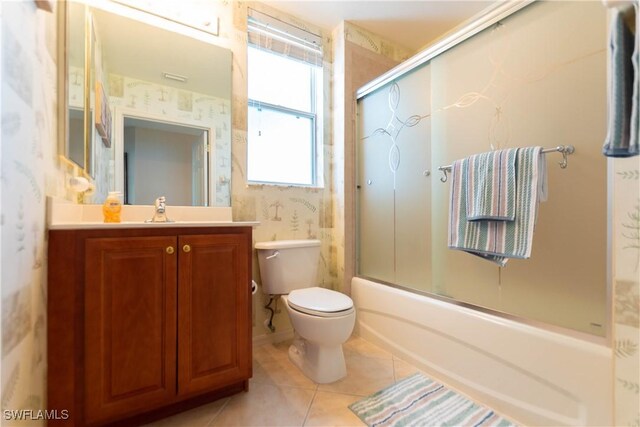 full bathroom featuring tile patterned floors, toilet, combined bath / shower with glass door, and vanity