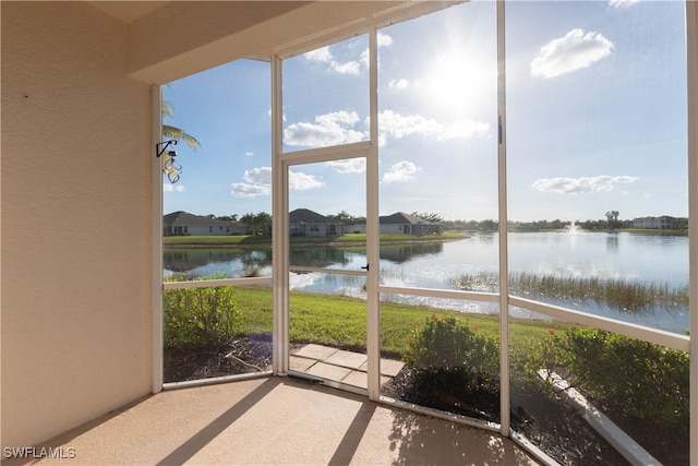 unfurnished sunroom featuring a water view