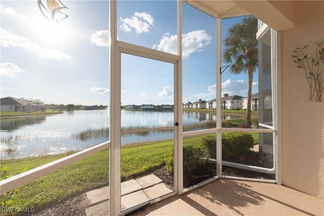 unfurnished sunroom featuring a water view