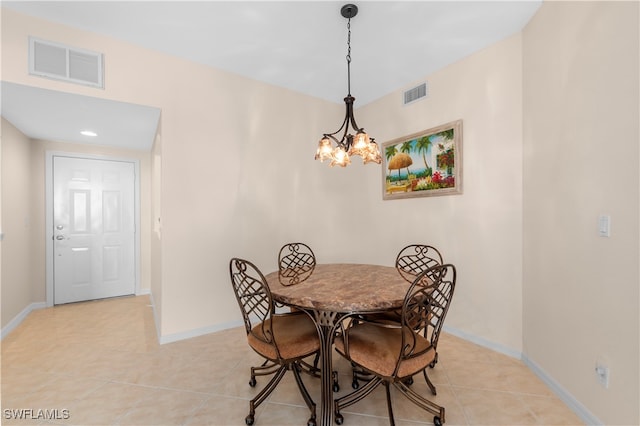 dining room with light tile patterned flooring and a chandelier