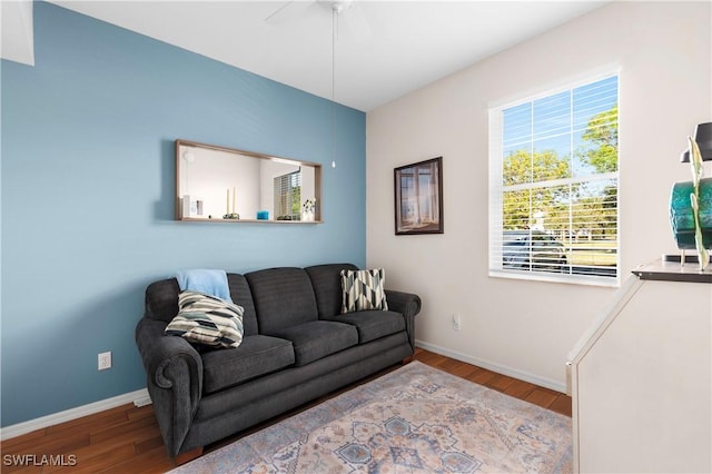 living room featuring ceiling fan, baseboards, and wood finished floors