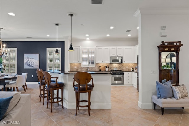 kitchen with a breakfast bar area, white cabinetry, stove, decorative backsplash, and decorative light fixtures