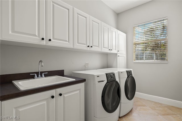 clothes washing area featuring cabinets, sink, and washing machine and clothes dryer